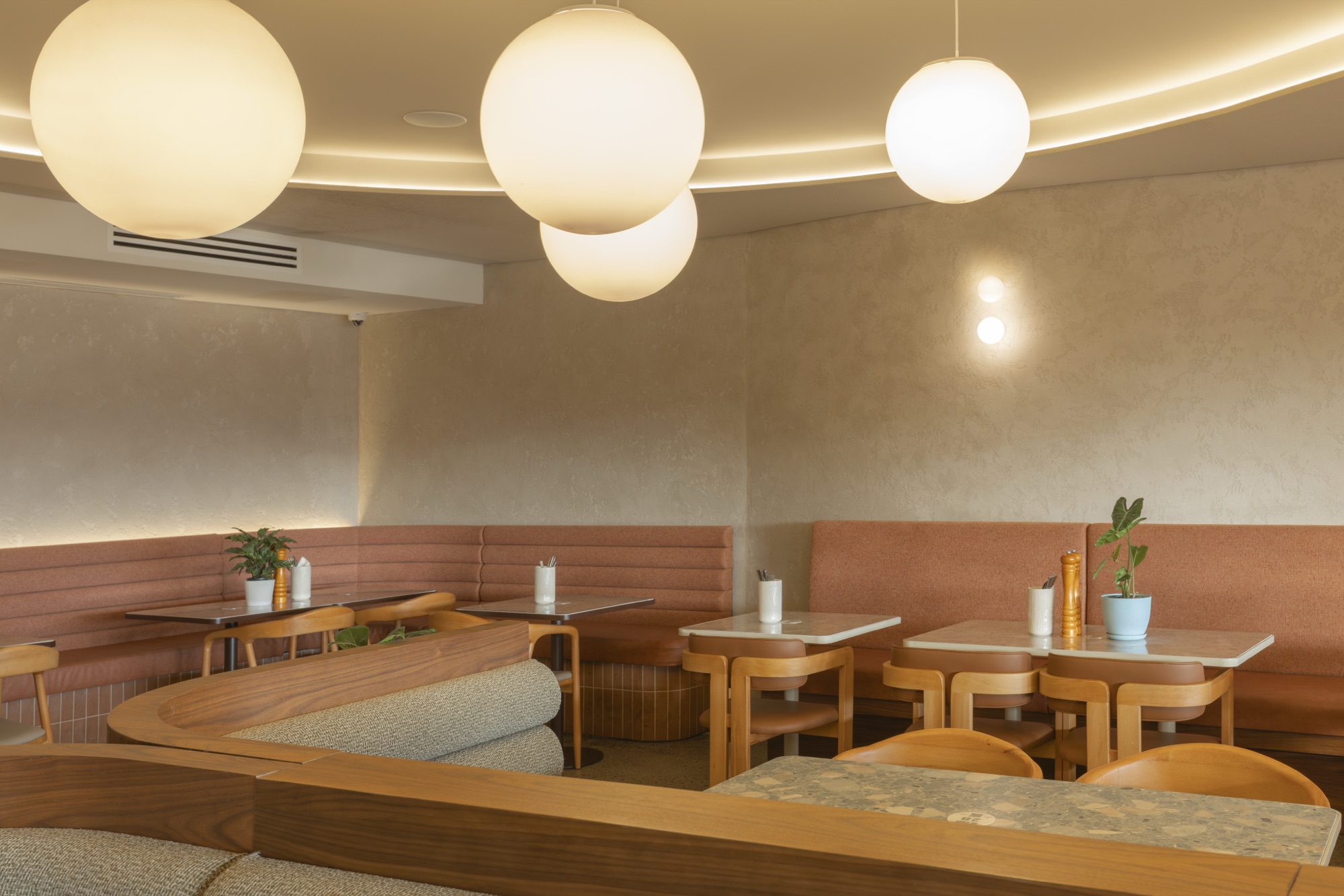 Curved interior dining nook with marble tables