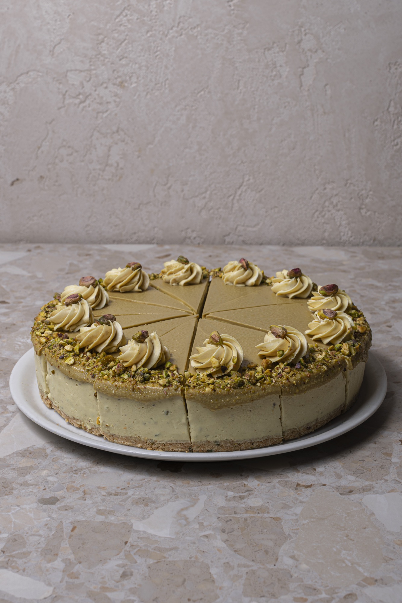Pistachio cake with cream rosettes and crushed pistachios