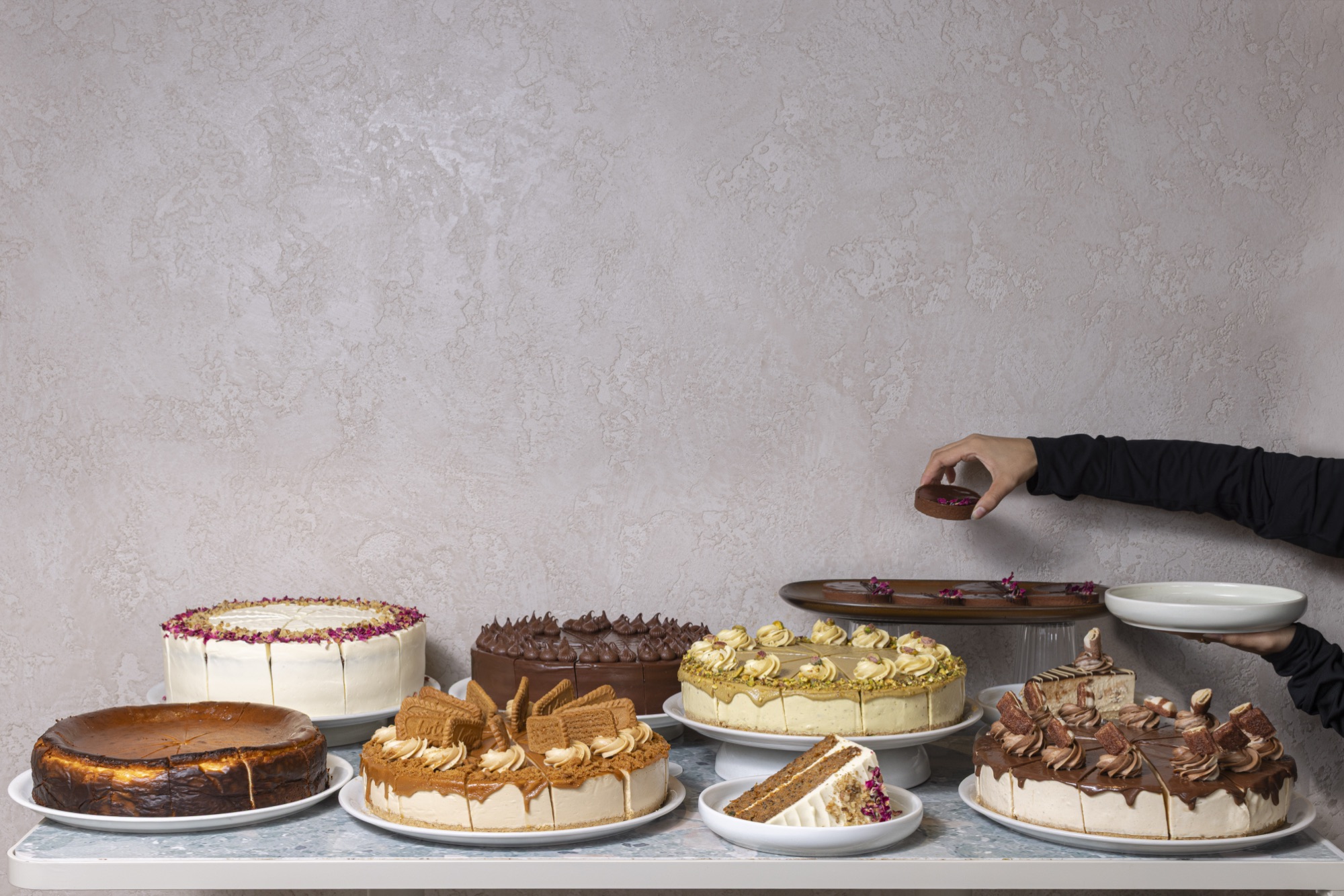 Cake display with hand reaching for chocolate truffle